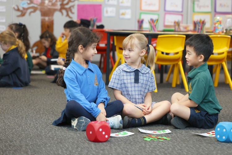 Three students sitting on classroom floor