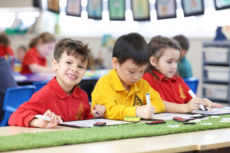 Three students sitting at a classroom desk